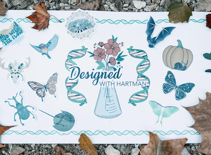 Sheet of stickers with various designs on a textured surface with leaves.